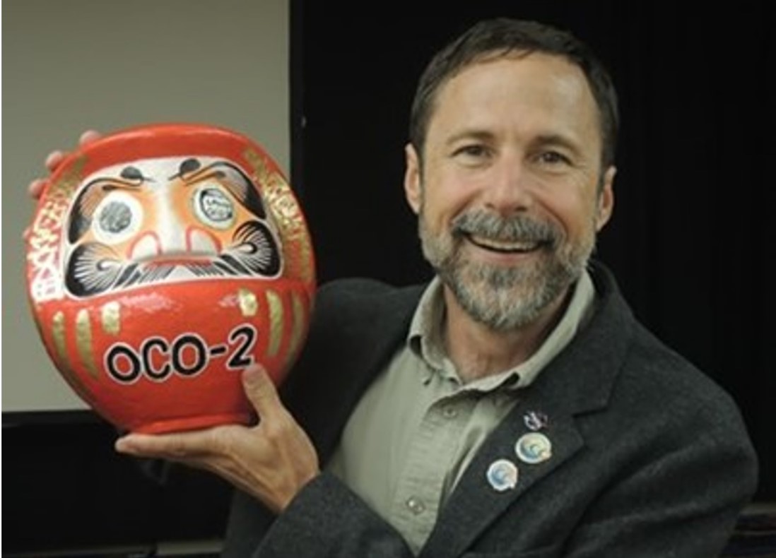  Dave Crisp holding a traditional Japanese Daruma doll, which is round and hollow, in celebration of the successful launch of OCO-2. This was a gift from Japan's GOSAT team. 