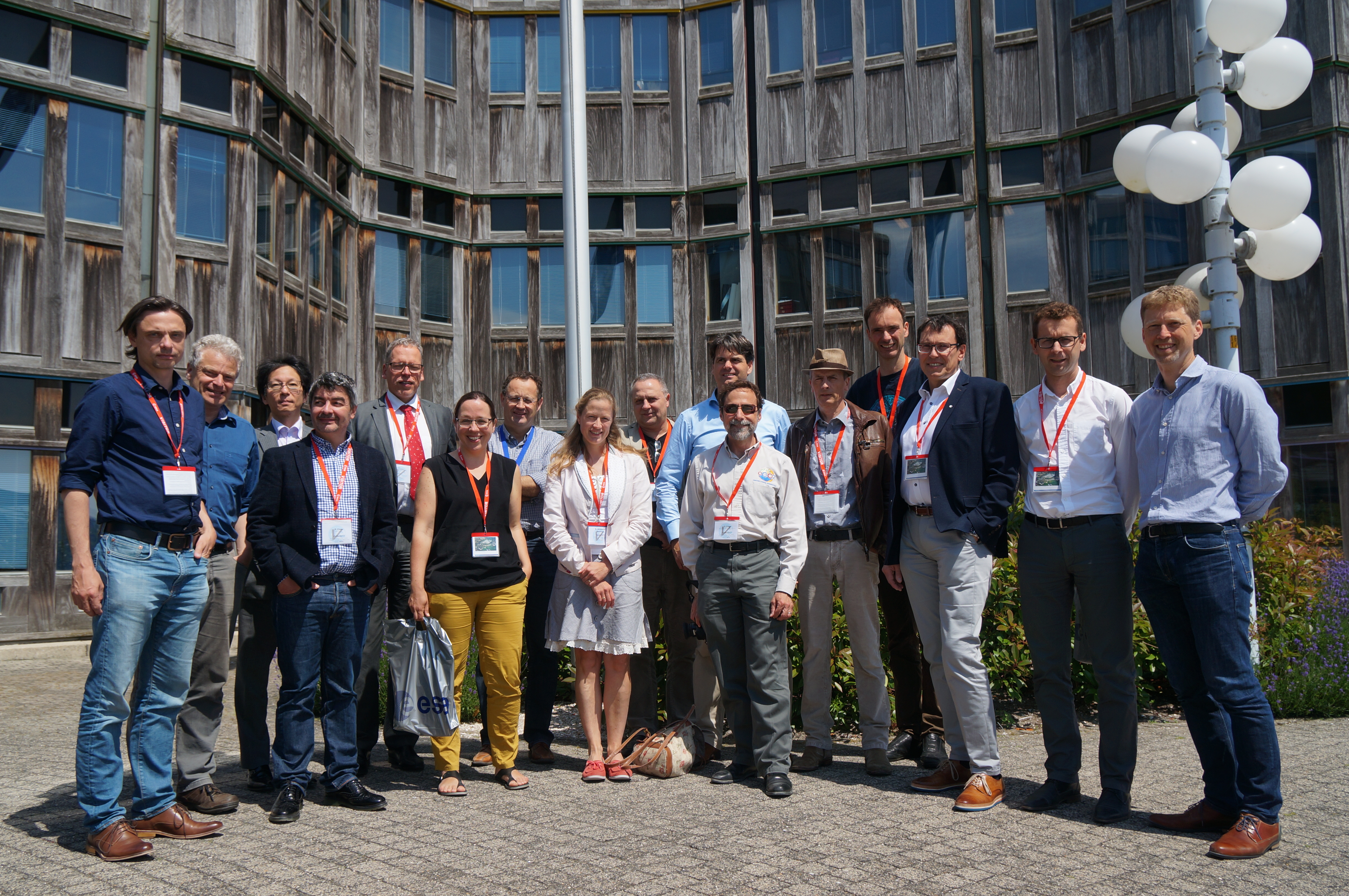 A group of about 20 scientists involved in efforts to measure carbon dioxide from space pose together outside on a sunny day in front of an agency building in the Netherlands, amongst them Dave Crisp