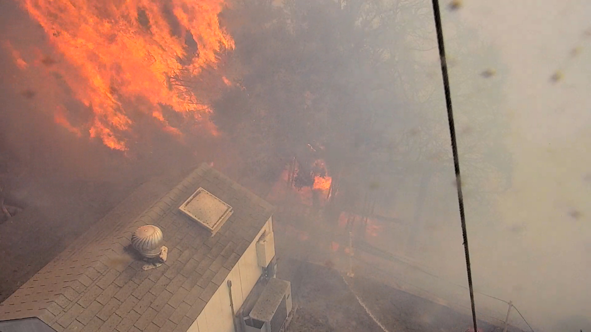 Smoke fills the scene. A splotch of bright orange in the top left corner signals a tree bursting into flames. It looms over a white shed with a slate roof in the bottom left corner.