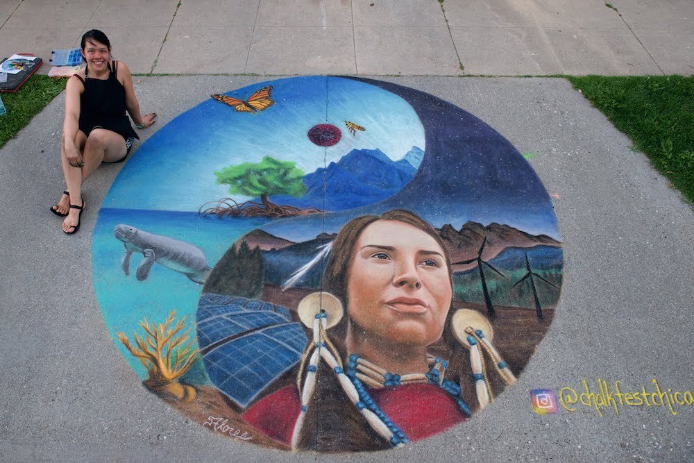 Sarah Flores sitting on the sidewalk with one of her chalk painting